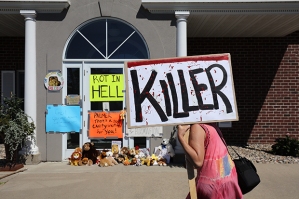 BLOOMINGTON, MN - JULY 29:  Protesters call attention to the alleged poaching of Cecil the lion, in the parking lot of Dr. Walter Palmer's River Bluff Dental Clinic on July 29, 2015 in Bloomington, Minnesota. According to reports, the 13-year-old lion was lured out of a national park in Zimbabwe and killed by Dr. Palmer, who had paid at least $50,000 for the hunt. (Photo by Adam Bettcher/Getty Images)